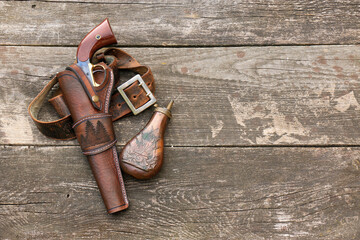 Black powder revolver in a leather holster with a leather belt and gunpowder flask on the...