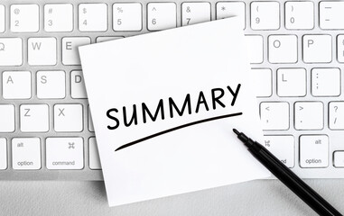 White paper with text Summary lying on the keyboard