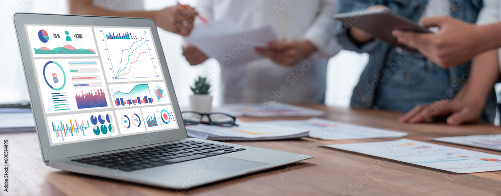 Poster Focus BI power dashboard display on laptop screen with blurred background of analyst team analyzing business financial data using BI Fintech software for business insight. Panorama shot. Scrutinize