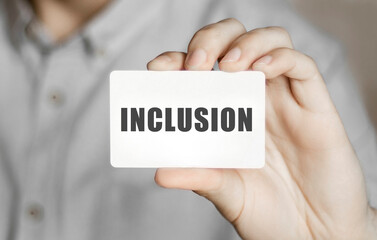 Card with text Inclusion in a man's hand