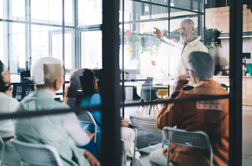 Successful male proud CEO explaining strategy to professional employees during brainstorming conference in office interior, group of financial experts discussing marketing while cooperate indoors