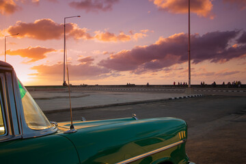 Auto clásico bajo una puesta de sol en la habana, fascinación del turismo.