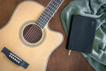Naklejka premium Guitar and bible book on wooden background, top view.