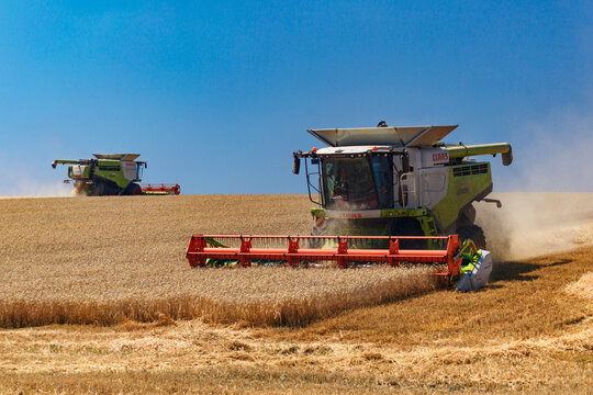  Ukraine. Kyiv. JULY 23, 2022: Modern combine Claas Lexion harvesting grain in the field.Combine harvest on grain field.Agricultural machine on the blue sky.