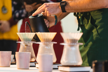 Pouring water over into a coffee pot.