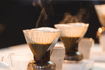 Coffee pots with filters brewing.