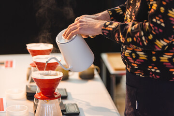 Pouring water over into a coffee pot.