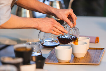 Fototapeta na wymiar Barista pouring coffee in coffee cups.