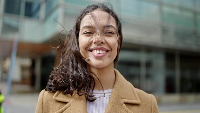 Young beautiful hispanic woman smiling confident at street