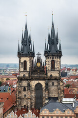 Fototapeta premium Aerial view of the facade of the Church of Our Lady before Tyn in Prague against a cloudy sky.