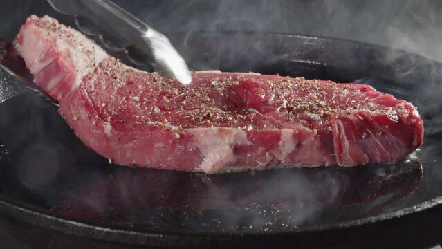 Grilling beef steak on iron plate 03