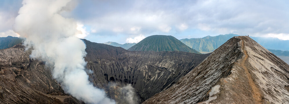 Hiking trail along the edge of Mount Bromo's crater with Mount Semeru, Mount Batok and the Sea of Sand (Segara Wedi) in the background, East, Java, Indonesia