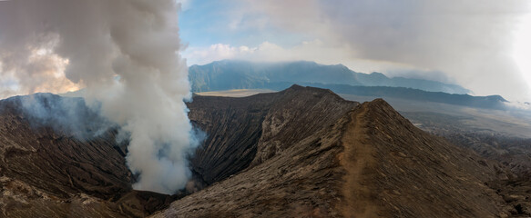 Hiking trail along the edge of Mount Bromo's crater with Mount Semeru, Mount Batok and the Sea of Sand (Segara Wedi) in the background, East, Java, Indonesia © Luis