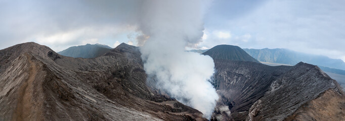 Hiking trail along the edge of Mount Bromo's crater with Mount Semeru, Mount Batok and the Sea of Sand (Segara Wedi) in the background, East, Java, Indonesia © Luis