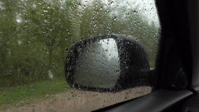 Car Mirror Behind Wet Glass