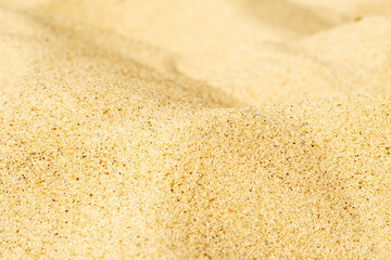 Close-up of yellow sand on the beach. Small grains of sand on a clean beach. Toned photo with low depth of field.
