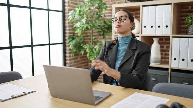 Young beautiful hispanic woman business worker stretching at office