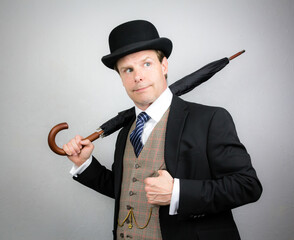 Portrait of Businessman in Suit and Bowler Hat Holding Umbrella. Classic British Gentleman.