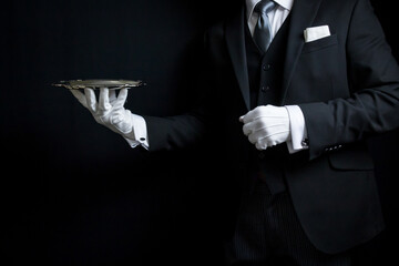 Portrait of Elegant Butler or Concierge in Dark Suit and White Gloves Holding Silver Serving Tray.