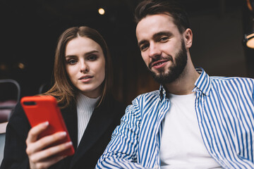 Stylish young couple chilling in cafeteria with smartphone
