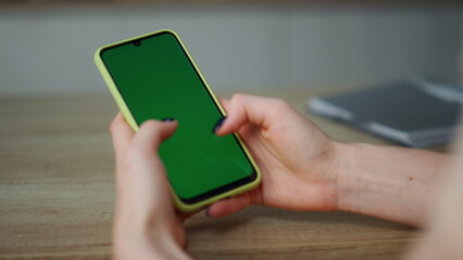 Hands green screen smartphone holding close up. Girl browsing Internet content.