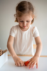 Fototapeta premium A little girl playing with plasticine. Sensory development and experiences, themed activities with children, fine motor skills development