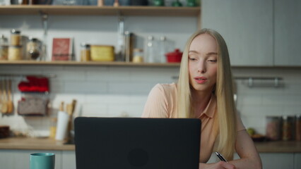 Freelancer taking online courses at laptop making notes closeup. Girl working.