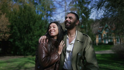 Romantic couple enjoying laughter and love in a peaceful park setting_ Authentic moment of happiness shared by happy boyfriend and girlfriend while strolling and embracing outdoors