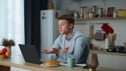 Man saying goodbye webcam finishing video call in kitchen. Guy closing laptop.