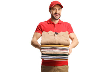 Male worker holding a pile of folded clothes and smiling