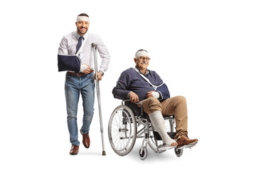 Young man with a broken arm and bandage on head leaning on a crutch and a mature man in a wheelchair