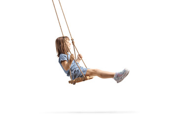 Full length profile shot of a happy little girl swinging on a wooden swing