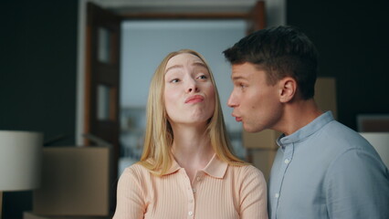 Abusive man scolding woman in new home close up. Young unhappy couple arguing.