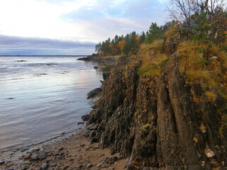 Fototapeta na wymiar Dark granite stone with thin layers on the shore of the White Sea. Republic of Karelia.