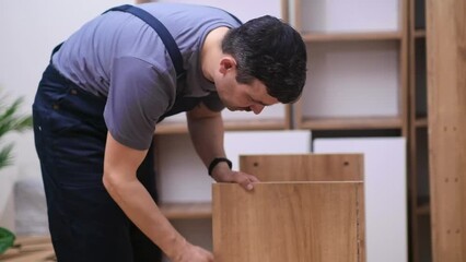 Custom furniture delivery and installation concentrated handyman checking planks made of quality hardwood ready to assemble rack for office interior carpentry industry