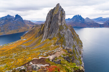 Obraz premium View from the ridge between Hesten mountain towards Segla mountain with Fjordgard in the deep on the left side and the slopes covered in autumn trees, Troms og Finnmark, Norway