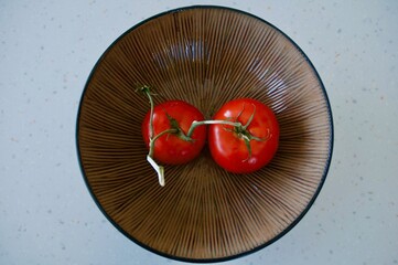 Red tomatoes in shiny wooden bowl