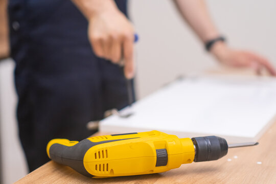 Furniture assembling process skilled master tightening screw nail in wooden rack using electric screwdriver high-quality woodwork profitable carpentry business