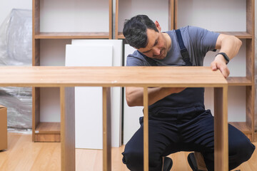 Furniture assembling and installation skilled master making wooden rack for home interior...