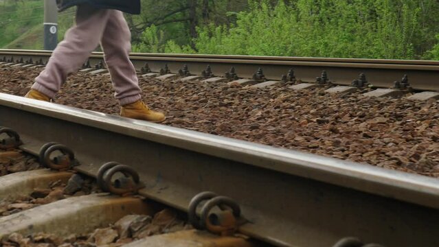 Middle-aged human feet crossing the railway