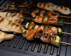 Skewers of fish and vegetables on wooden skewers Fry on an electric grill. healthy food without oil. Red fish (Salmon, trout) with grilled zucchini