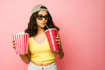 Beautiful teenager at the movies drinking soda