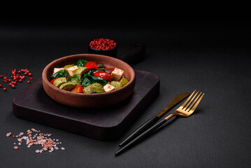 Delicious fresh salad of zucchini, cheese, sweet peppers, spinach with spices and herbs