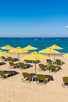 Beach on the mediterranean sea. Yellow beach umbrellas and sunbeds.