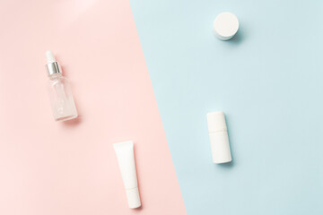 Creative flat lay of cosmetic bottles and jars on two colored background
