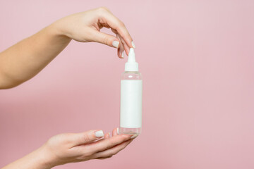 Cosmetic bottle in woman's hands. Cosmetic product branding mockup. Spa beauty treatment concept