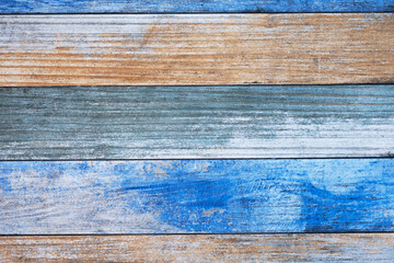 old wooden board with bright blue and beige paint and cracks. horizontal lines. rough surface texture