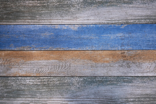 old wooden boards with bright blue and beige paint. horizontal lines. rough surface texture