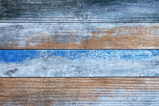 wooden boards with bright blue and beige paint. horizontal lines. rough surface texture