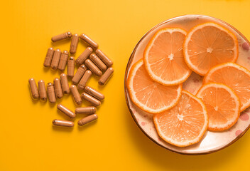 kratom pills composition on yellow background with orange slices